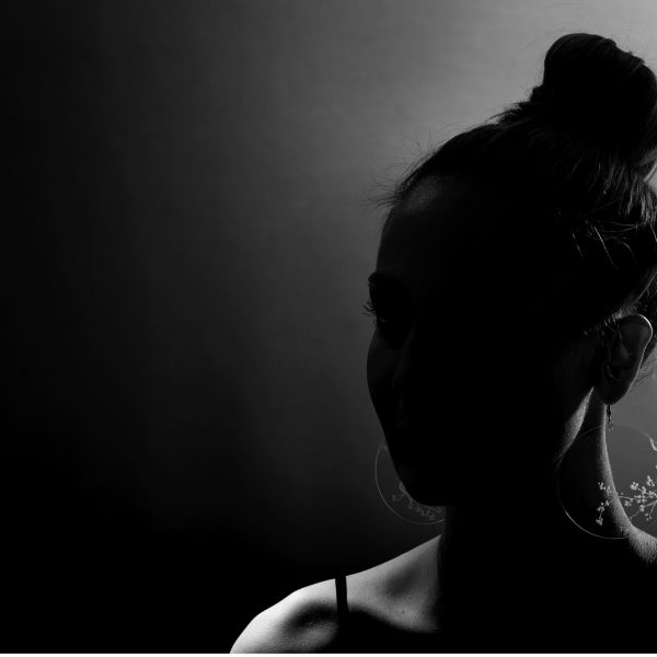 Fille avec des boucle d'oreille en plexiglas transparent gravé à la main de branche de cerisiers